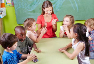 group of children clapping hands in kindergarten in musical education class
