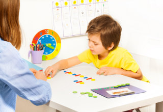 Concentrated boy putts colorful coins during ABA